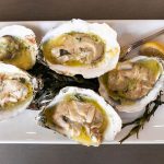 Wood-grilled oysters topped with parmesan butter.